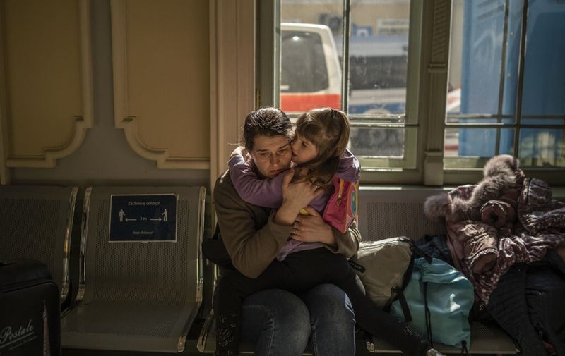 A Ukrainian evacuee hugs a child in the train station in Przemysl, near the Polish-Ukrainian border, on March 22, 2022, following Russia's military invasion launched on Ukraine. - The UN says almost 3,6 million people have fled Ukraine since the Russian invasion, with more than two million of them heading to neighbouring Poland. (Photo by Angelos Tzortzinis / AFP)