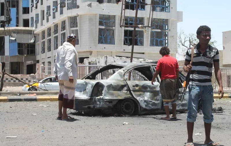 Armed militiamen loyal to Yemen&#8217;s fugitive President Abderabbo Mansour Hadi inspect the wreckage of a car reportedly belonging to Huthi rebels which was destroyed in an air strike by Saudi-led forces at the Caltex roundabout in the Mansoura district of the southern port city of Aden, on April 17, 2015. According to a provincial official [&hellip;]
