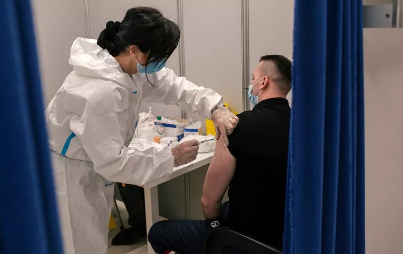 A Serbian medical worker administers a dose of a coronavirus (Covid-19) vaccine at a vaccination centre in a shopping mall of Belgrade on May 6, 2021. - Serbia's president said on May 5, 2021, that his country would pay each citizen who gets a Covid jab before the end of May, in what could be the world's first cash-for-jabs scheme. The Balkans country bought millions of doses -- from Western firms as well as China and Russia -- and briefly became a regional vaccine hub when it offered foreigners the chance to be inoculated. (Photo by Vladimir Zivojinovic / STR / AFP)