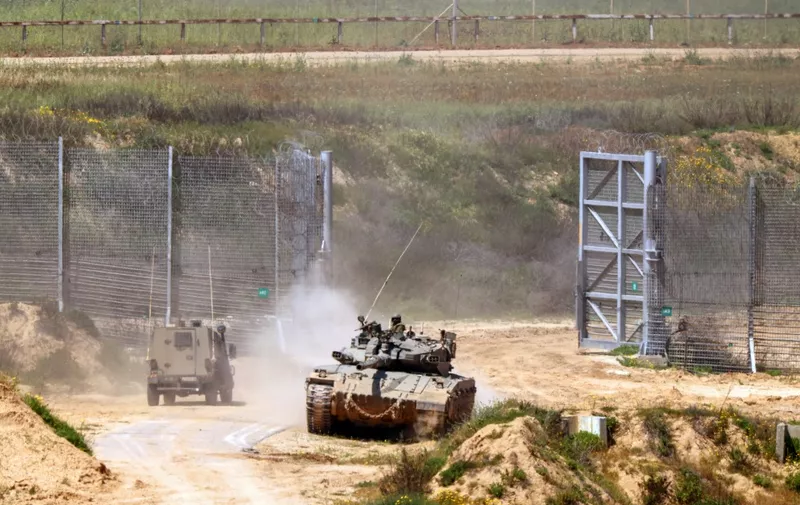 Israeli army vehicles move in an area along the border with the Gaza Strip and southern Israel on April 4, 2024, amid the ongoing conflict in the Palestinian territory between Israel and the militant group Hamas. (Photo by JACK GUEZ / AFP)