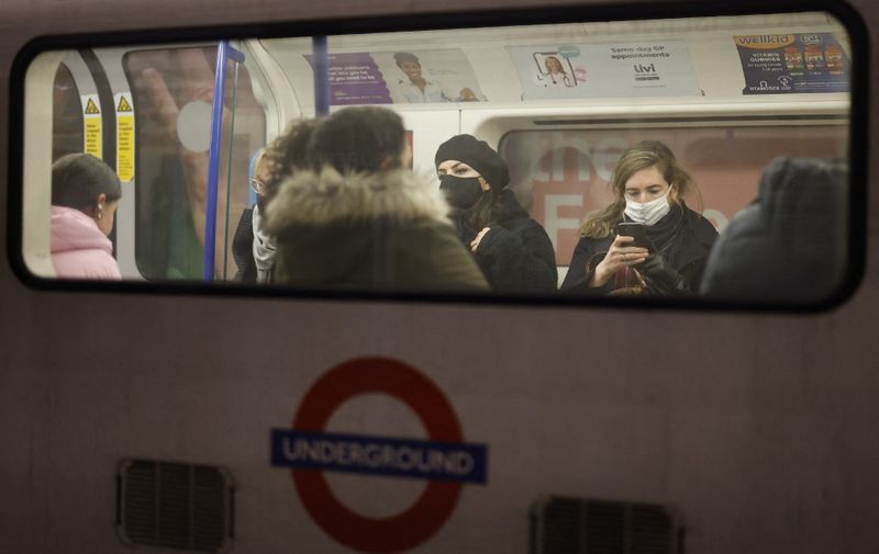 Passengers, many wearing face coverings to combat the spread of Covid-19, travel on the London underground in central London on November 28, 2021. - Health Secretary Sajid Javid said mandatory mask-wearing will return to shops and public transport in England on Tuesday, and told families to plan for Christmas "as normal", despite new rules to combat the Omicron variant. (Photo by Tolga Akmen / AFP)