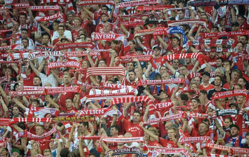 Fans of Bayern Munich cheer during the German first division Bundesliga football match FC Bayern Munich vs Hamburger SV at the Allianz Arena in Munich, southern Germany, on August 14, 2015. The match is the first of the 2015/2016 season. AFP PHOTO / DPA SVEN HOPPE +++ GERMANY OUT +++

RESTRICTIONS: DURING MATCH TIME: DFL RULES TO LIMIT THE ONLINE USAGE TO 15 PICTURES PER MATCH AND FORBID IMAGE SEQUENCES TO SIMULATE VIDEO. 
== RESTRICTED TO EDITORIAL USE ==
FOR FURTHER QUERIES PLEASE CONTACT DFL DIRECTLY AT + 49 69 650050.