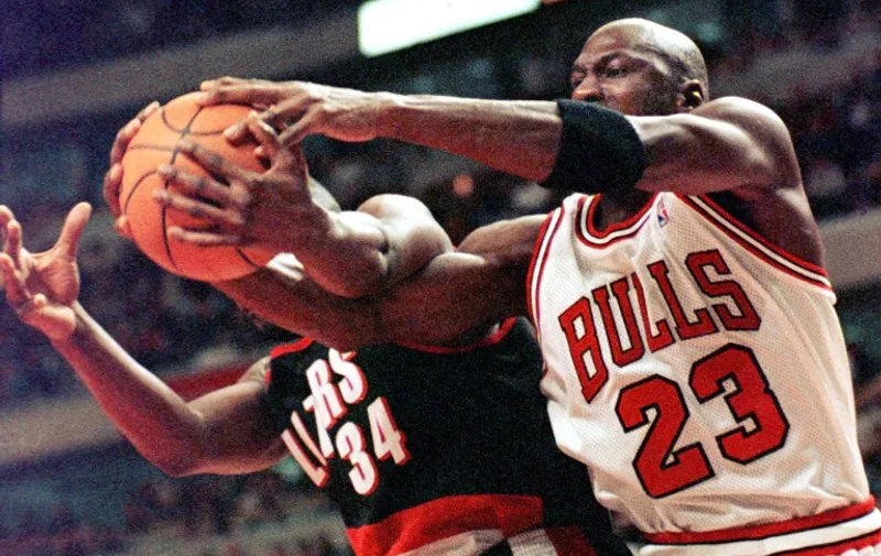 Chicago Bulls guard Michael Jordan(R) fights for a rebound with Portland Trail Blazers guard Isaiah Rider(L) during the third quarter 25 February, at the United Center in Chicago, Illinois. The Trail Blazers defeated the Bulls 106-101. 
  AFP PHOTO VINCENT LAFORET