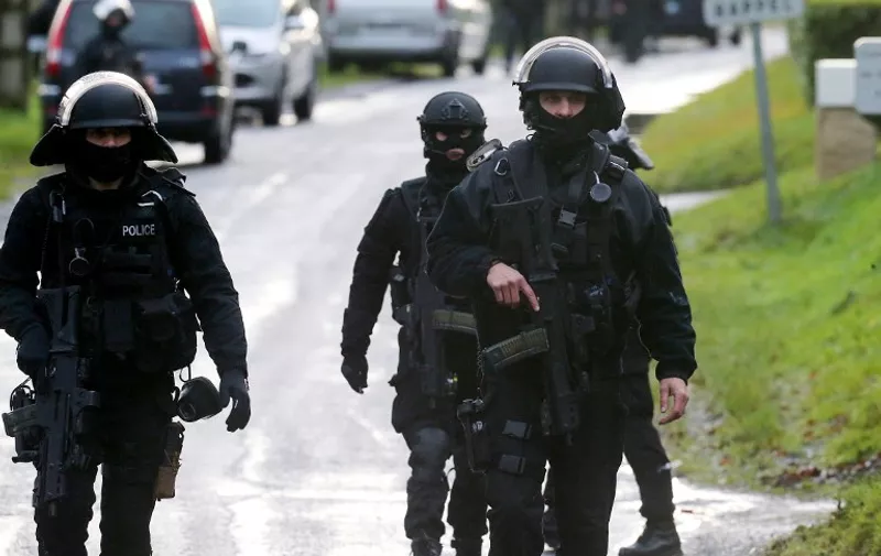 Members of GIPN and of RAID, French police special forces, are pictured in Corcy, near Villers-Cotterets, north-east of Paris, on January 8, 2015, where the two armed suspects from the attack on French satirical weekly newspaper Charlie Hebdo were spotted in a gray Clio. French security forces deployed on January 8 in a northern town where two brothers suspected of having gunned down 12 people in an Islamist attack on satirical magazine Charlie Hebdo abandoned their car, a police source said. Cherif Kouachi, 32, a jihadist well-known to police, and his brother Said, 34, were spotted by the manager of a petrol station in the town about an hour's drive northeast of Paris, who after being robbed "formally identified" the two men. AFP PHOTO / FRANCOIS NASCIMBENI