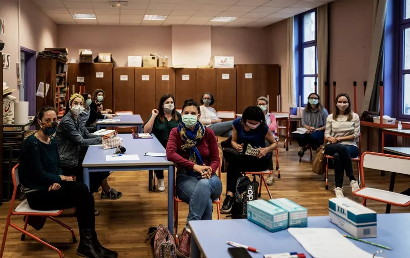 School teachers wearing masks attend a preparation meeting at Berthelot school in Lyon on May 11, 2020 as primary schools prepare to re-open, on the first day of France's easing of lockdown measures in place for 55 days to curb the spread of the COVID-19 pandemic, caused by the novel coronavirus. (Photo by JEFF PACHOUD / AFP)