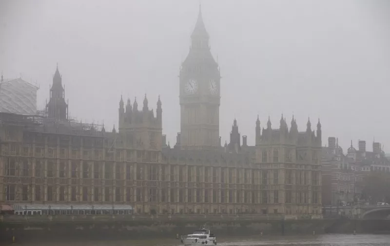 A boat travels along the River Thames through the fog past the Houses of Parliament in central London on November 2, 2015. Thick fog across much of Britain caused travel disruption on November 2, 2015 with 10 percent of flights cancelled from London Heathrow, Europe's busiest airport. AFP PHOTO / JUSTIN TALLIS
