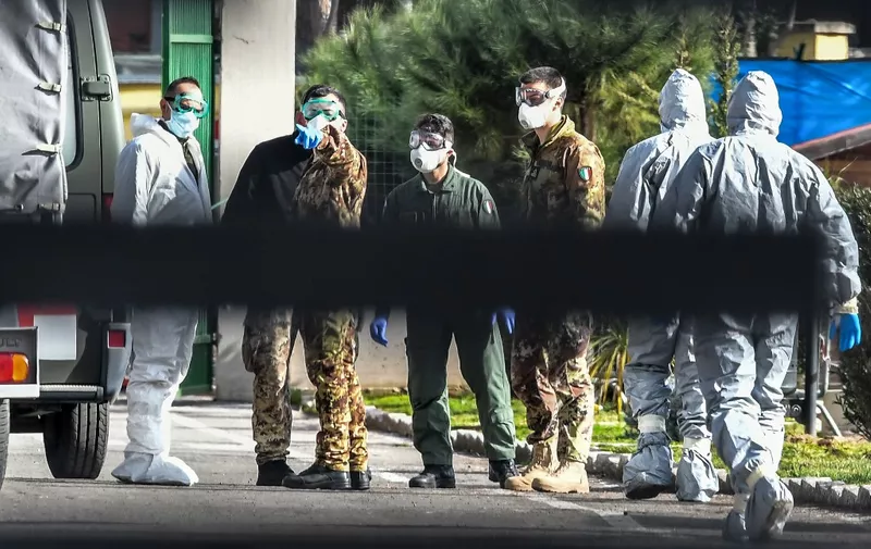 Military personnel wearing protective gear stand inside the Cecchignola quarantine center, south of Rome, on February 3, 2020 as Italian citizens arrived at the center after being repatriated from the coronavirus hot-zone of Wuhan and landing at the nearby military airport of Pratica di Mare. (Photo by Tiziana FABI / AFP)