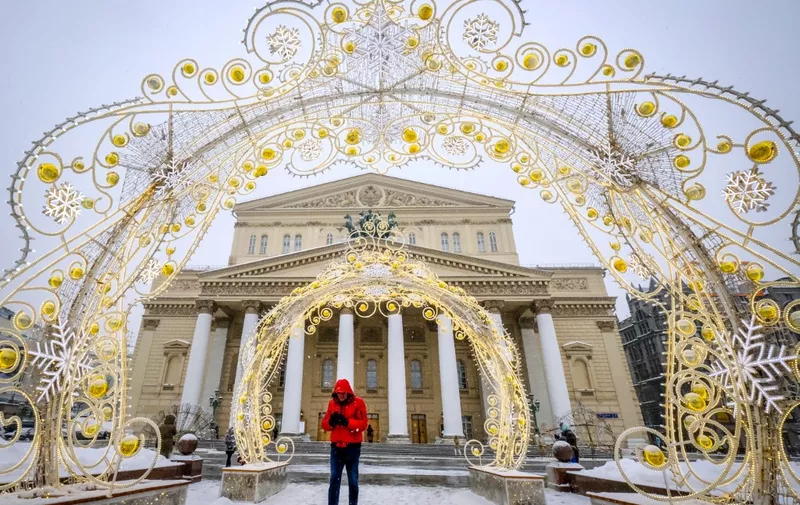A man walks in the snow in front of the Bolshoi theatre in central Moscow on February 21, 2021. (Photo by Yuri KADOBNOV / AFP)
