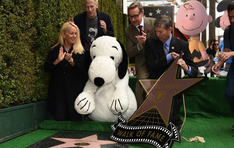 Snoopy reacts as his star is unveiled on the Hollywood Walk of Fame, November 2, 2015 in Hollywood, California.  Snoopy co-stars with Charlie Brown and Lucy in "The Peanuts Movie" which opens in the US on November 6, 2015.  With Snoopy from left are Beth Marlis, chair of the Hollywood Chamber of Commerce, producer Paul Feign, Hollywood Chamber of Commerce President and CEO Leron Gubler and writer Craig Schulz.   AFP PHOTO / ROBYN BECK