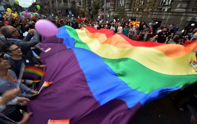 Participants of the Belgrade Gay Pride parade carry a giant rainbow flag on September 20, 2015. The participants of Belgrade Gay Pride parade, held without incidents and under tight security, urged Sunday for European solidarity with migrants traveling across Balkans towards European Union. The march, the second in a row since the event was marred by violence in 2010, was held without incidents amid tight security as thousands of riot police officers were deployed in the city center.   AFP PHOTO / ANDREJ ISAKOVIC / AFP / ANDREJ ISAKOVIC