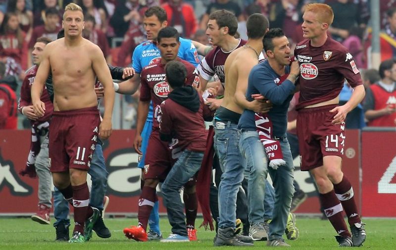 Torino's players celebrate with supporters at the end of the Italian Serie A football match between Torino and Juventus on April 26, 2015 at the "Olympic Stadium" in Turin.  AFP PHOTO / MARCO BERTORELLO