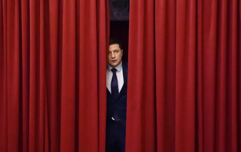 Ukrainian comic actor and the presidential candidate Volodymyr Zelensky enters a hall in Kiev on March 6, 2019, to take part in the shooting of the television series "Servant of the People" where he plays the role of the President of Ukraine. - Anger with the political elite is partly behind the rise of Volodymyr Zelensky, a TV actor with no political experience who is the frontrunner in the upcoming presidential vote.  Zelensky is polling at 25 percent, ahead of Poroshenko on 17 percent and former prime minister Yulia Tymoshenko on 16 percent as of March 4, 2019. (Photo by Sergei SUPINSKY / AFP)