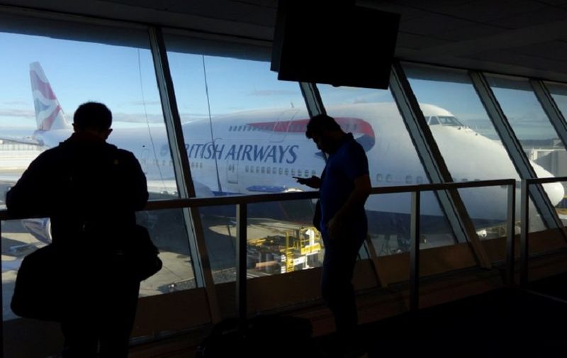 Passengers looks at a British Airway flight at John F. Kennedy (JFK) international airport in New York, on May 27, 2017.                
British Airways cancelled all its flights out of major London airports Heathrow and Gatwick on after an IT systems failure, leaving hundreds stranded on a busy holiday weekend. / AFP PHOTO / William EDWARDS