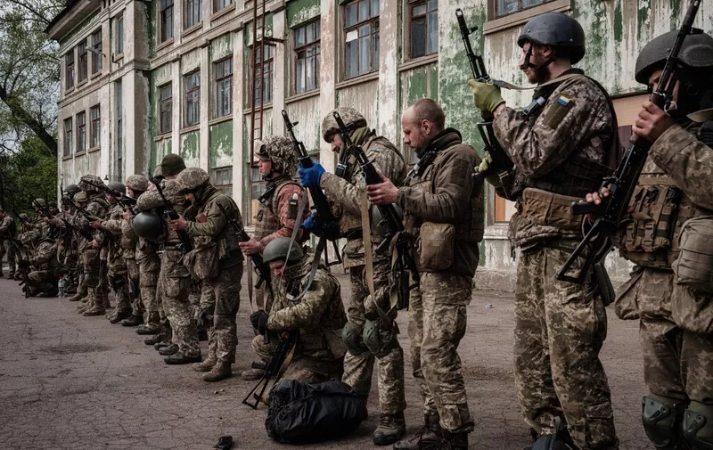 Ukrainian soldiers unload their guns as they arrive at an abandoned building to rest and receive medical treatment after fighting on the front line for two months near Kramatorsk, eastern Ukraine on April 30, 2022. - Russia invaded Ukraine on February 24, 2022. (Photo by Yasuyoshi CHIBA / AFP)