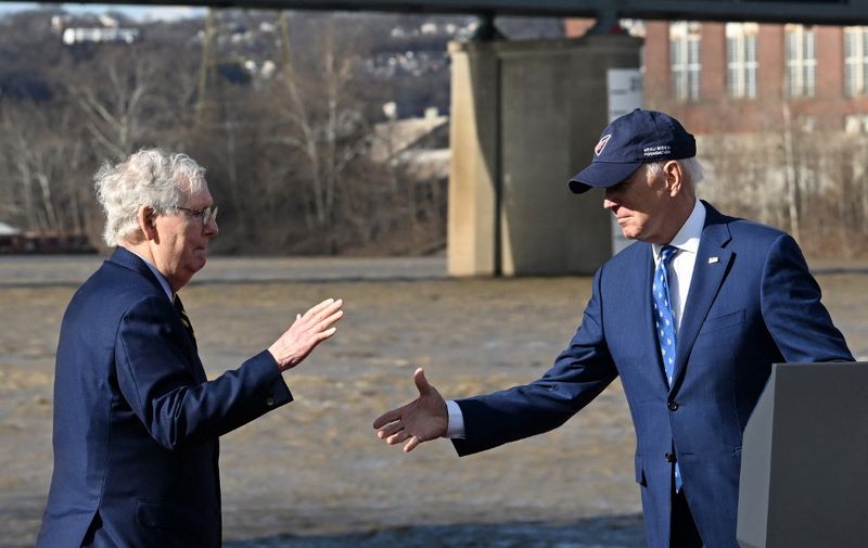 US President Joe Biden (R) shakes hands with Senate Minority Leader Mitch McConnell during an event about the bipartisan infrastructure law in front of the Clay Wade Bailey Bridge in Covington, Kentucky, on January 4, 2023. (Photo by Jim WATSON / AFP)