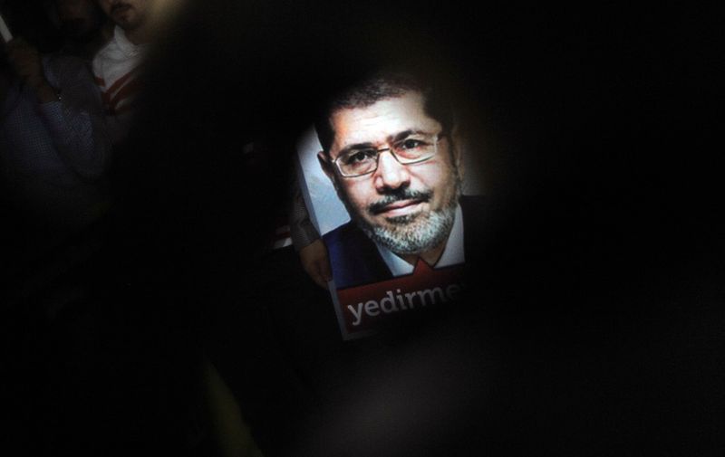 (FILES) In this file photo taken on July 02, 2013 A poster of Egypt's President Mohamed Morsi is seen during a pro-Morsi demonstration in Istanbul. - Former Egyptian President Mohamed Morsi died on June 17, 2019 in a Cairo hospital after fainting in a court session, a judicial and security source said. (Photo by Ozan KOSE / AFP)
