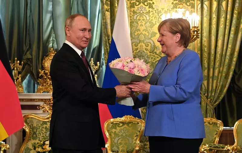 Russian President Vladimir Putin (L) welcomes German Chancellor Angela Merkel during their meeting at the Kremlin in Moscow, August 20, 2021. - The trip will be the 20th and last visit to Russia for Angela Merkel as German Chancellor, who bows out of politics following an election in Germany on September 26, 2021. (Photo by Evgeny ODINOKOV / SPUTNIK / AFP)