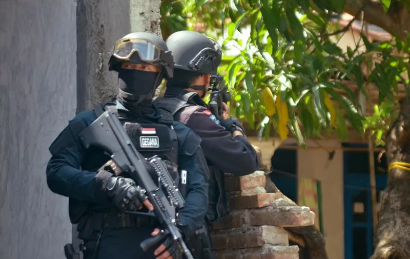 The Elite Indonesian police commando belonging to Densus 88 raids a house of a suspected terrorist in Cirebon, located in western Java island, on January 15, 2016 following the January 14, 2016 bomb attacks in Jakarta. 
Indonesian police launched raids across the country on January 15, 2016 in the wake of deadly coordinated attacks. The January 14, 2016 combination of suicide bombings and shootings in the capital left five attackers and two other people dead. Two dozen other people were wounded -- three foreigners, six police officers and the rest Indonesian civilians. / AFP / STRINGER