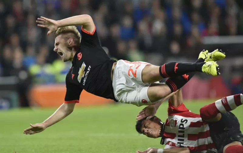Manchester's defender Luke Shaw (L) is challenged by Eindhoven's Mexican defender Hector Moreno during the UEFA Champions League Group B football match between PSV Eindhoven and Manchester United at the Philips stadium in Eindhoven, Belgium on September 15, 2015. AFP PHOTO / JOHN THYS