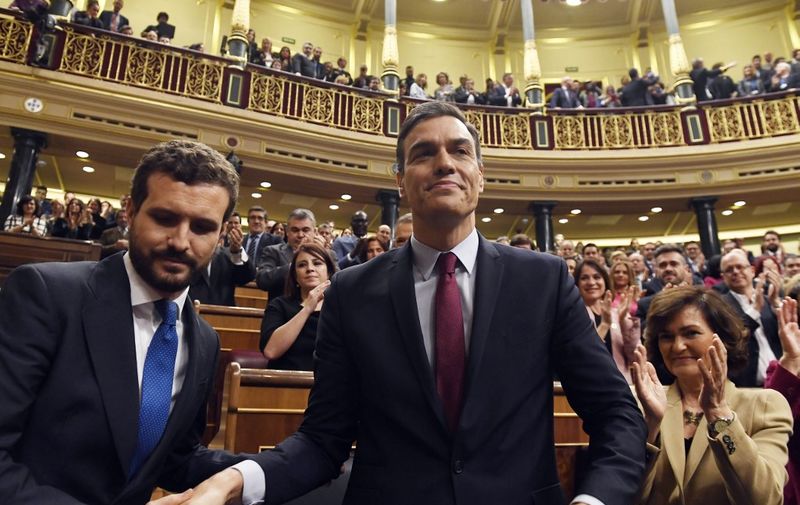 Spanish caretaker prime minister, socialist Pedro Sanchez, is congratulated by Spanish conservative People's Party (PP) leader, Pablo Casado (L), after winning a parliamentary vote to elect a premier at the Spanish Congress (Las Cortes) in Madrid on January 7, 2020. - Spain's parliament today confirmed Socialist leader Pedro Sanchez by a razor-thin margin as prime minister for another term at the helm of the country's first-ever coalition government since its return to democracy in the 1970s. Sanchez, who has stayed on as a caretaker premier since inconclusive elections last year, got 167 votes in favour in the 350-seat assembly comapred to 165 against, with 18 abstentions from Catalan and Basque separatist lawmakers. (Photo by PIERRE-PHILIPPE MARCOU / AFP)