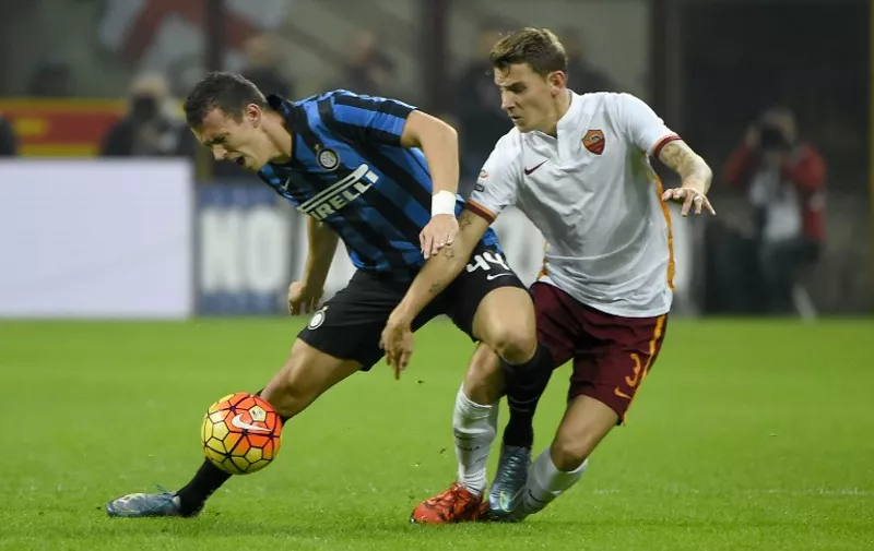 Roma's French defender Luca Digne (R) fights for the ball with Inter Milan's Croatian midfielder Ivan Peresic during the Italian Serie A football match Inter Milan versus AS Roma on October 31, 2015 at the San Siro Stadium stadium in Milan. AFP PHOTO / OLIVIER MORIN