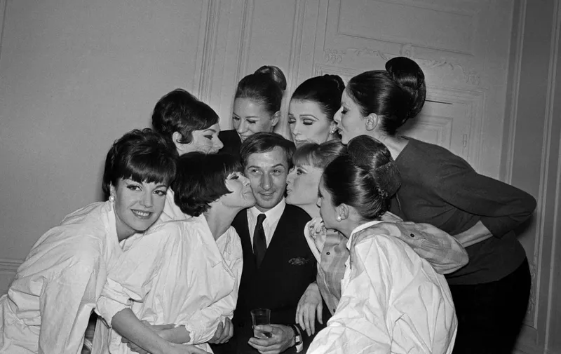 Pictura taken on January 28, 1965 at Paris showing French fashion designer Marc Bohan surrounded and gratulated by the fashion models after the Dior Spring-Summer 1965 collection's presentation. (Photo by AFP)