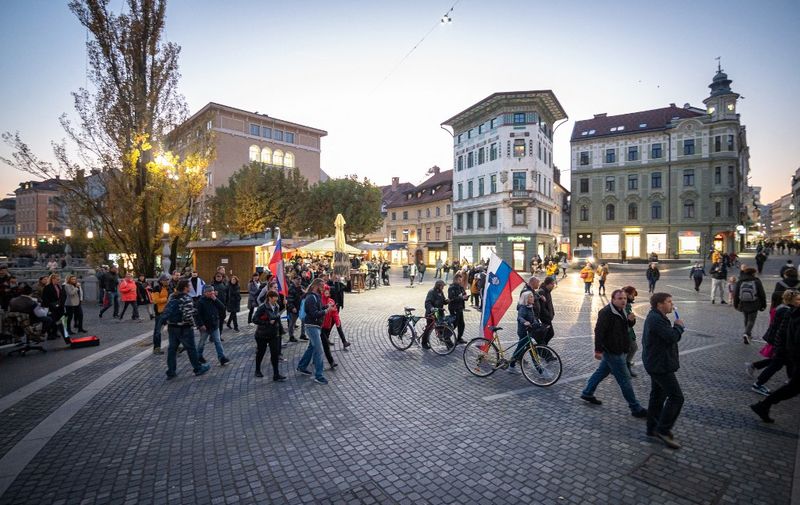 Protesters hold flags and banners as they walk during a rally against Covid-19 restrictions in Ljubljana on October 27, 2021. (Photo by Jure Makovec / AFP)