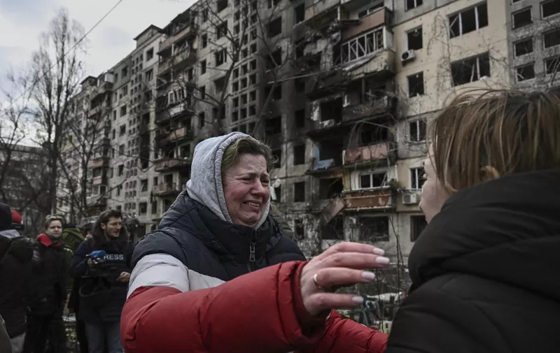 EDITORS NOTE: Graphic content / A woman reacts as she stands outside destroyed apartment blocks following shelling in the northwestern Obolon district of Kyiv on March 14, 2022. - Two people were killed on March 14, 2022, as various neighbourhoods of the Ukraine capital Kyiv came under shelling and missile attacks, city officials said, after the Russia's military invaded the Ukraine on February 24, 2022. (Photo by Aris Messinis / AFP)
