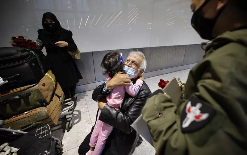 Relatives embrace as they arrive from the United States at Heathrow's Terminal 5 in west London on August 2, 2021 as quarantine restrictions ease. - People fully vaccinated in the United States and European Union, except France will now be allowed to travel to England without having to quarantine on arrival. (Photo by Tolga Akmen / AFP)