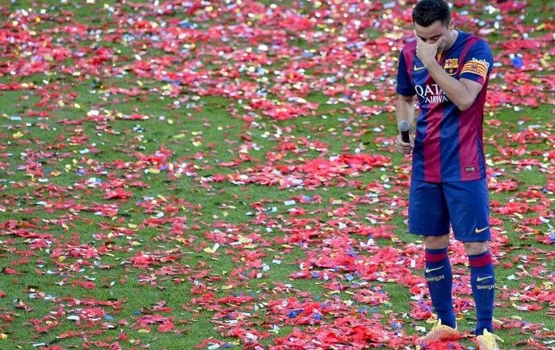 Barcelona's midfielder Xavi Hernandez cries as he speaks to the crowd following his last match for the club after the Spanish league football match FC Barcelona vs RC Deportivo La Coruna at the Camp Nou stadium in Barcelona on May 23, 2015.    AFP PHOTO / JOSEP LAGO
