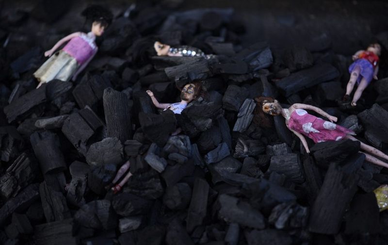 Dolls representing the 29 victims of a fire at government-run children's shelter in San Jose Pinula, east of Guatemala City, are seen amid a pile of carbon as part of a demonstration named "Guatemala is Not a Safe Place" and performed by artists of the group Project 44 in front of the presidential house in the Guatemalan capital on March 9, 2017.
Medical officials on Thursday raised the toll of girls killed in a fire at a children's shelter in Guatemala to 29 after seven more died from their burns overnight. More than 30 were injured.
 / AFP PHOTO / Johan ORDONEZ