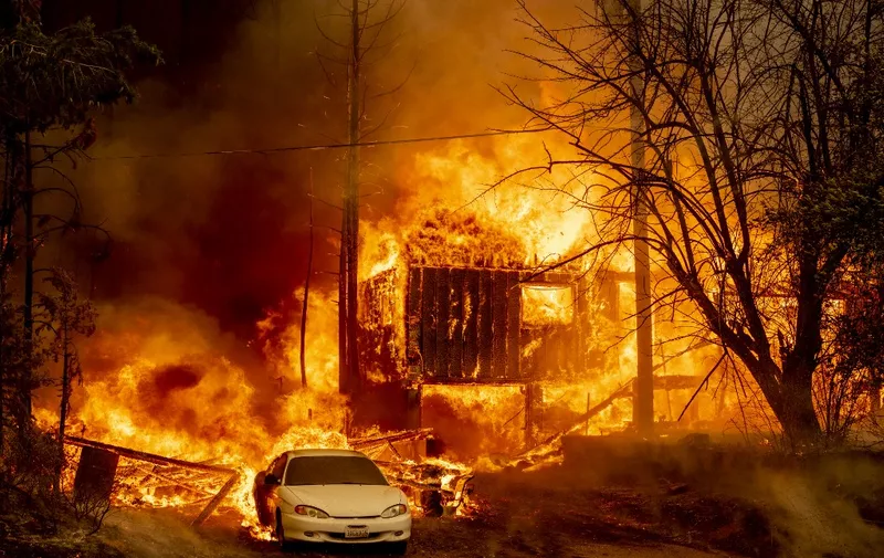 A home is engulfed in flames as the Dixie fire rages on in Greenville, California on August 5, 2021. - The largest wildfire in California has razed a small town, warping street lights and destroying historic buildings hours after residents were ordered to flee. 
Greenville, an Indian Valley settlement of a few hundred people dating back to the mid-1800s Gold Rush, was engulfed by flames as winds whipped the inferno towards the community, turning the sky orange. (Photo by JOSH EDELSON / AFP)