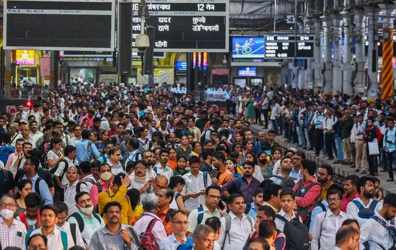 (FILES) In this file photo taken on April 19, 2023, people crowd on platforms as they wait for their train at the Chhatrapati Shivaji Terminus (CST) railway station in Mumbai. - Every morning and evening -- and for several hours in between -- tens of millions of Indians sit idle on gridlocked highways and hang from the sides of packed passenger trains in what is becoming the world's most populous nation. (Photo by Punit PARANJPE / AFP)