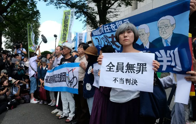 Activists hold placards in reaction during a rally in front of the Tokyo District Court in Tokyo on September 19, 2019, after the court acquitted three former officials from the firm that operated the Fukushima nuclear plant. - The Japanese court on September 19 acquitted three former officials from Tokyo Electric Power Company (TEPCO), in the only criminal trial to stem from the 2011 nuclear disaster. (Photo by Kazuhiro NOGI / AFP)