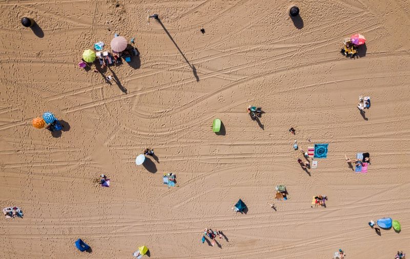 An aerial photo of the first beach-goers on the beach of Scheveningen on July 24, 2019 as western Europe endures a heatwave. (Photo by Sem van der Wal / ANP / AFP) / Netherlands OUT