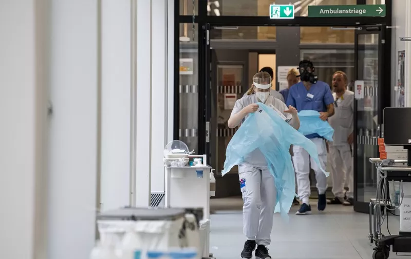 Healthcare workers put on protective gear as they prepare to receive a patient at the Intensive Care Unit (ICU) at Danderyd Hospital near Stockholm on May 13, 2020, during the coronavirus COVID-19 pandemic. (Photo by Jonathan NACKSTRAND / AFP)