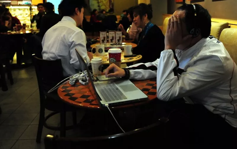 A man surfs the Internet at a cafe in Beijing on December 6, 2009. Chinese authorities have offered rewards of up to 10,000 yuan (1,465 dollars) to Internet users who report websites that feature pornography, state media reported. However, the censors' latest campaign against content that harms public morality appears to have encouraged Internet users to look for porn online.  AFP PHOTO/Frederic J. BROWN / AFP PHOTO / FREDERIC J. BROWN