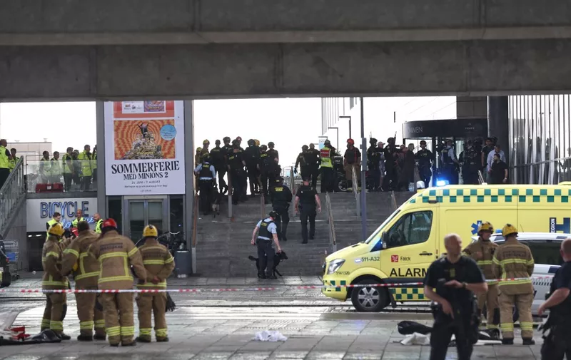 Police officers and rescuers are seen in front of the Fields shopping center in Oerested in Copenhagen, on July 3, 2022, after a shooting took place in the shopping center. - Gunfire in a Copenhagen mall on July 3, 2022 left several dead and several wounded, Danish police said, adding they had arrested one person in his twenties. (Photo by Olafur Steinar Gestsson / Ritzau Scanpix / AFP) / Denmark OUT