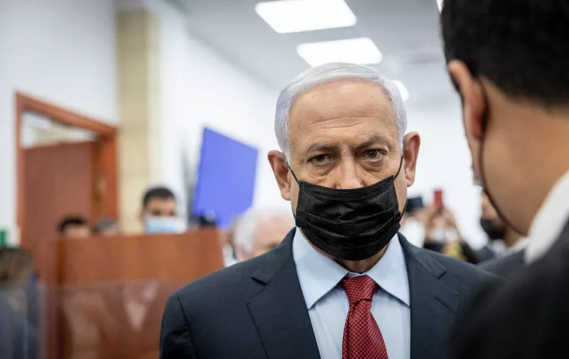 Former Israeli prime minister Benjamin Netanyahu stands at the courtroom in the Jerusalem District Court, on March 23, 2022. - Netanyahu is facing trial on charges of bribery, fraud and breach of trust in three separate cases. (Photo by Yonatan SINDEL / POOL / AFP)