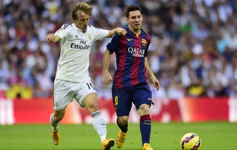 Barcelona's Argentinian forward Lionel Messi  (R) vies with Real Madrid's Croatian midfielder Luka Modric  during the Spanish league football match Real Madrid CF vs FC Barcelona at the Santiago Bernabeu stadium in Madrid on October 25, 2014.   AFP PHOTO/ JAVIER SORIANO / AFP / JAVIER SORIANO