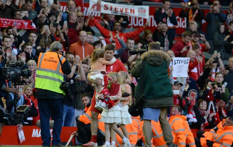 Liverpool's English midfielder Steven Gerrard (C) does a lap of the pitch with his daughters Lilly-Ella, Lexie and Lourdes to say farewell to the fans at the end of the English Premier League football match between Liverpool and Crystal Palace at the Anfield stadium in Liverpool, northwest England, on May 16, 2015.  Liverpool captain Steven Gerrard told supporters he was "devastated" about leaving the club during an on-pitch address after his final game at Anfield. Gerrard, 34, will join the Los Angeles Galaxy in July after almost 17 years at his home-town club and following a 3-1 loss to Crystal Palace, he paid an emotional tribute to Liverpool's fans. AFP PHOTO / OLI SCARFF

RESTRICTED TO EDITORIAL USE. No use with unauthorized audio, video, data, fixture lists, club/league logos or live services. Online in-match use limited to 45 images, no video emulation. No use in betting, games or single club/league/player publications.