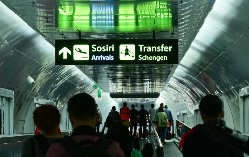 Travelers walk next to newly installed signs pointing to Schengen transfer flights areas, minutes after midnight, just after Romania's official entry into the European area of free circulation at Otopeni's "Henri Coanda" international airport on March 31, 2024. Bulgaria and Romania joined Europe's vast Schengen area of free movement on March 31, opening up travel by air and sea without border checks after a 13-year wait. A veto by Austria however means the new status will not apply to land routes, after Vienna expressed concerns over a potential influx of asylum seekers. Despite the partial membership, the lifting of controls at the two countries' air and sea borders is of significant symbolic value. (Photo by Daniel MIHAILESCU / AFP)