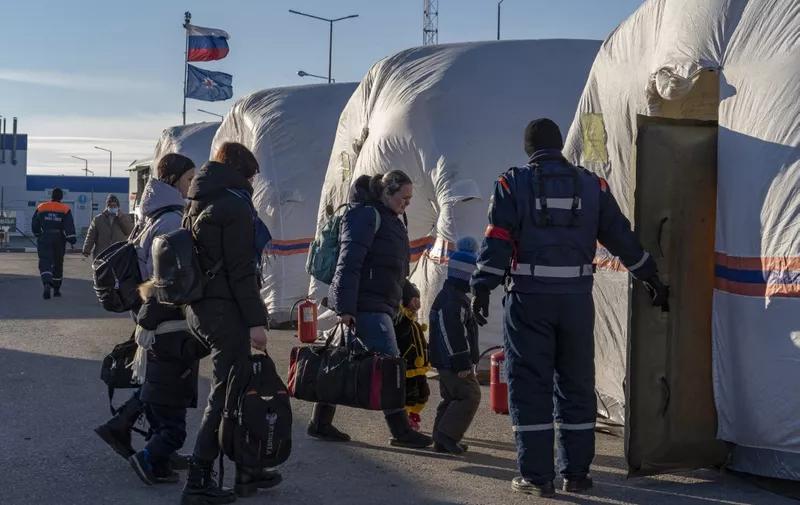 People evacuated from the self-proclaimed Donetsk People's Republic enter a tent at the Russian Emergency Ministry camp in the village of Veselo-Voznesenka on the Azov Sea coast, on February 19, 2022. - A Russian region bording Ukraine declared a state of emergency on February 19, 2022, citing growing numbers of people arriving from separatist-held regions in Ukraine after they received evacuation orders. (Photo by Andrey BORODULIN / AFP)