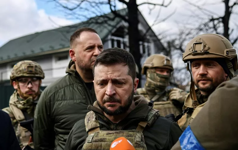 Ukainian President Volodymyr Zelensky (C) speaks to the press in the town of Bucha, northwest of the Ukrainian capital Kyiv, on April 4, 2022. - Ukraine's President Volodymyr Zelensky said on April 3, 2022 the Russian leadership was responsible for civilian killings in Bucha, outside Kyiv, where bodies were found lying in the street after the town was retaken by the Ukrainian army. (Photo by RONALDO SCHEMIDT / AFP)