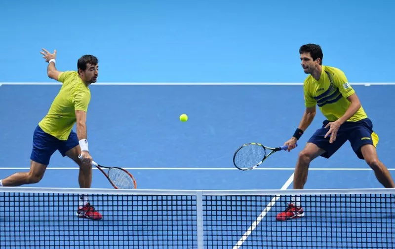 Brazil's Marcelo Melo (R) and Croatia's Ivan Dodig (L) play against Poland's Marcin Matkowski and Serbia's Nenad Zimonjic during their men's doubles group stage match on day six of the ATP World Tour Finals tennis tournament in London on November 20, 2015.  AFP PHOTO / GLYN KIRK / AFP / GLYN KIRK