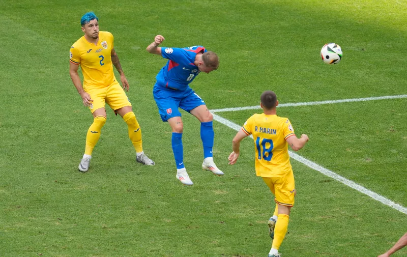 Slovakia's Ondrej Duda, center, heads the ball to scores his side's opening goal against Romania during a Group E match at the Euro 2024 soccer tournament in Frankfurt, Germany, Wednesday, June 26, 2024. (AP Photo/Darko Vojinovic)