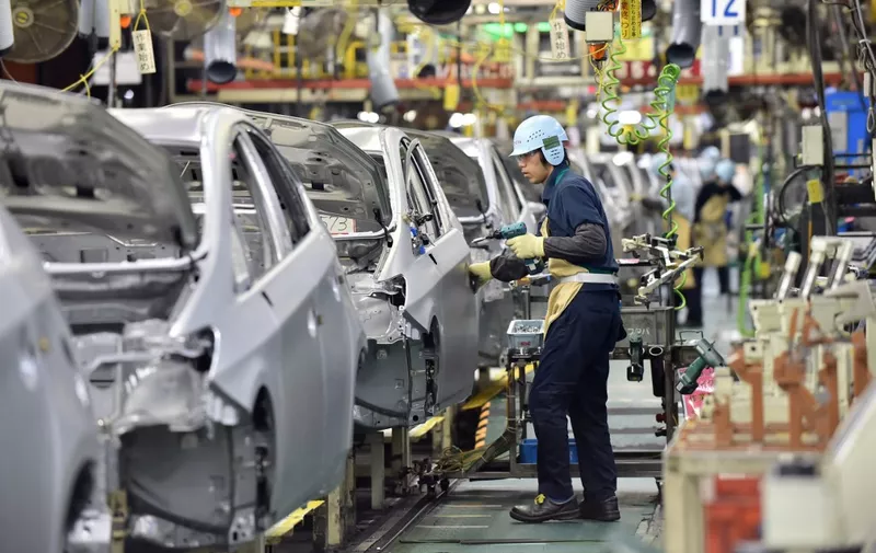 People work on the production line of the Toyota Motor Prius at the company's Tsutsumi plant in Toyota, Aichi prefecture on December 4, 2014.  AFP PHOTO / KAZUHIRO NOGI (Photo by KAZUHIRO NOGI / AFP)