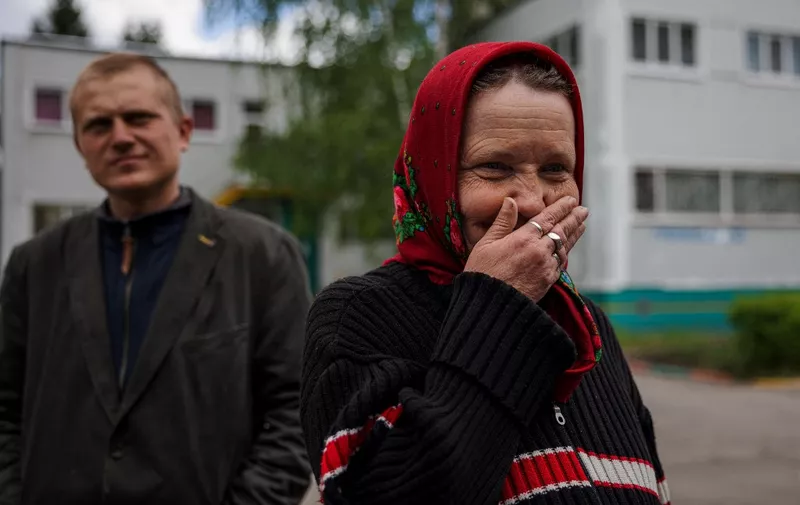 Galina Chistyakova, 60, evacuated from the village of Ruska Lozova reacts in a yard at the kindergarten 420, that was converted in a refugee shelter in Kharkiv on May 18, 2022, on the 84th day of the Russian invasion of Ukraine. - Thousands of evacuees from villages and neighborhoods hit by fighting or shelling are currently taking refuge in the regional capital waiting to return home. (Photo by Dimitar DILKOFF / AFP)