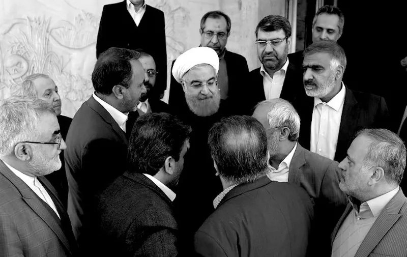 A handout picture provided by the office of Iranian President Hassan Rouhani shows him (C) on January 1, 2018 greeting heads of parliamentary commissions before a meeting in the capital Tehran.
Rouhani acknowledged there was "no problem bigger than unemployment" in a speech on December 31st, and also vowed a more balanced media and more transparency as the Iranian authorities continue to crack down on the biggest anti-regime demonstrations in years. / AFP PHOTO / IRANIAN PRESIDENCY / HO / == RESTRICTED TO EDITORIAL USE - MANDATORY CREDIT "AFP PHOTO / HO / IRANIAN PRESIDENCY" - NO MARKETING NO ADVERTISING CAMPAIGNS - DISTRIBUTED AS A SERVICE TO CLIENTS ==
