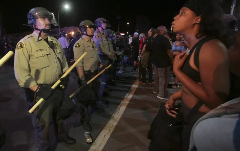 Protesters face off with police in El Cajon, a suburb of San Diego, California on September 28, 2016, in response to a police shooting the night before of Ugandan refugee Alfred Olango.
Protesters marched in a California town following the fatal police shooting of an unarmed black man said to be mentally ill, as local officials urged calm and pledged a full investigation.  / AFP PHOTO / Bill Wechter